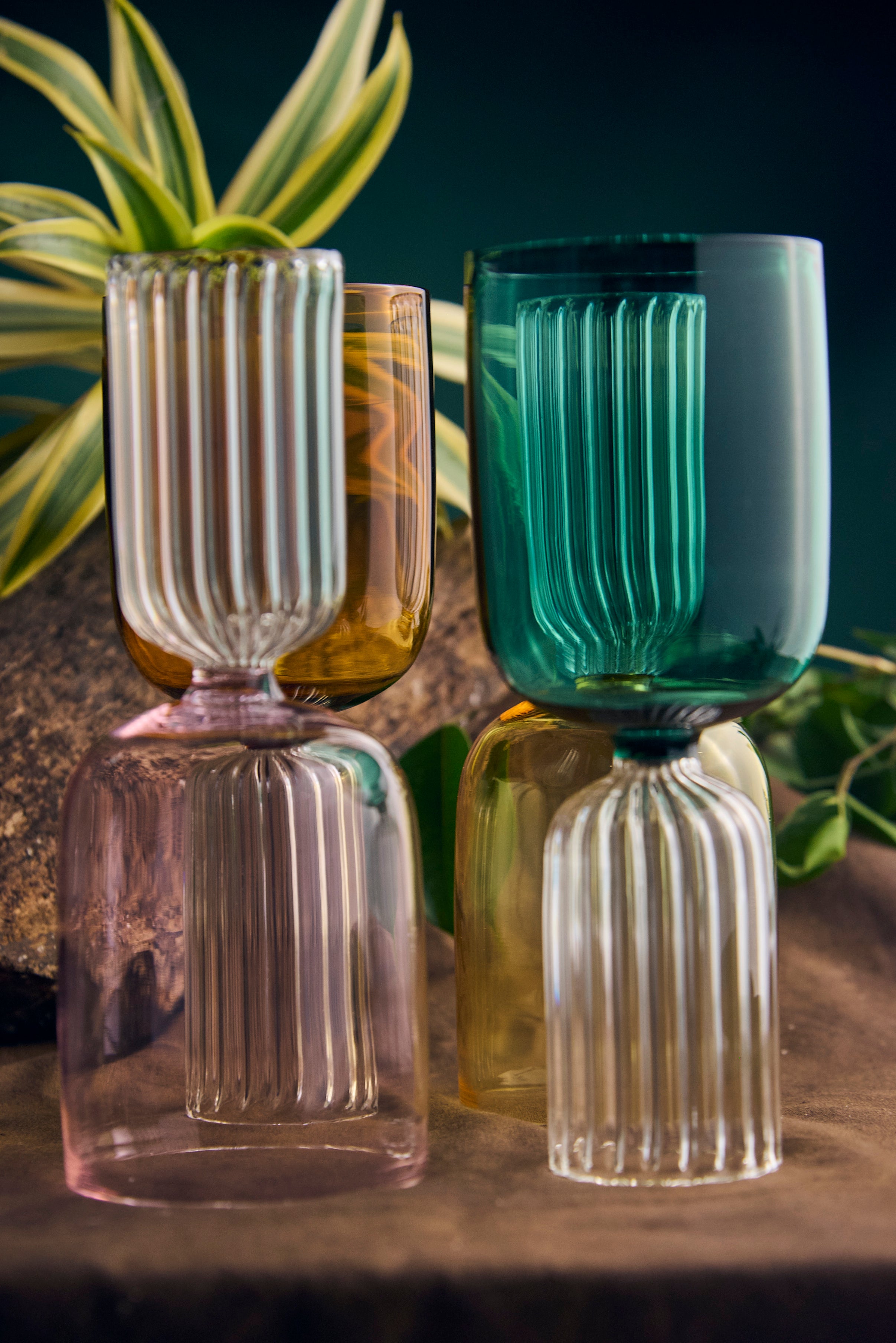 Coloured designer glassware handmade artistic drinking glass Handmade coloured designer drinking glass on modern dining table Close-up of handmade coloured glassware with artistic design Set of coloured designer glassware handmade drinking glasses Artistic coloured designer glassware modern drinking glass