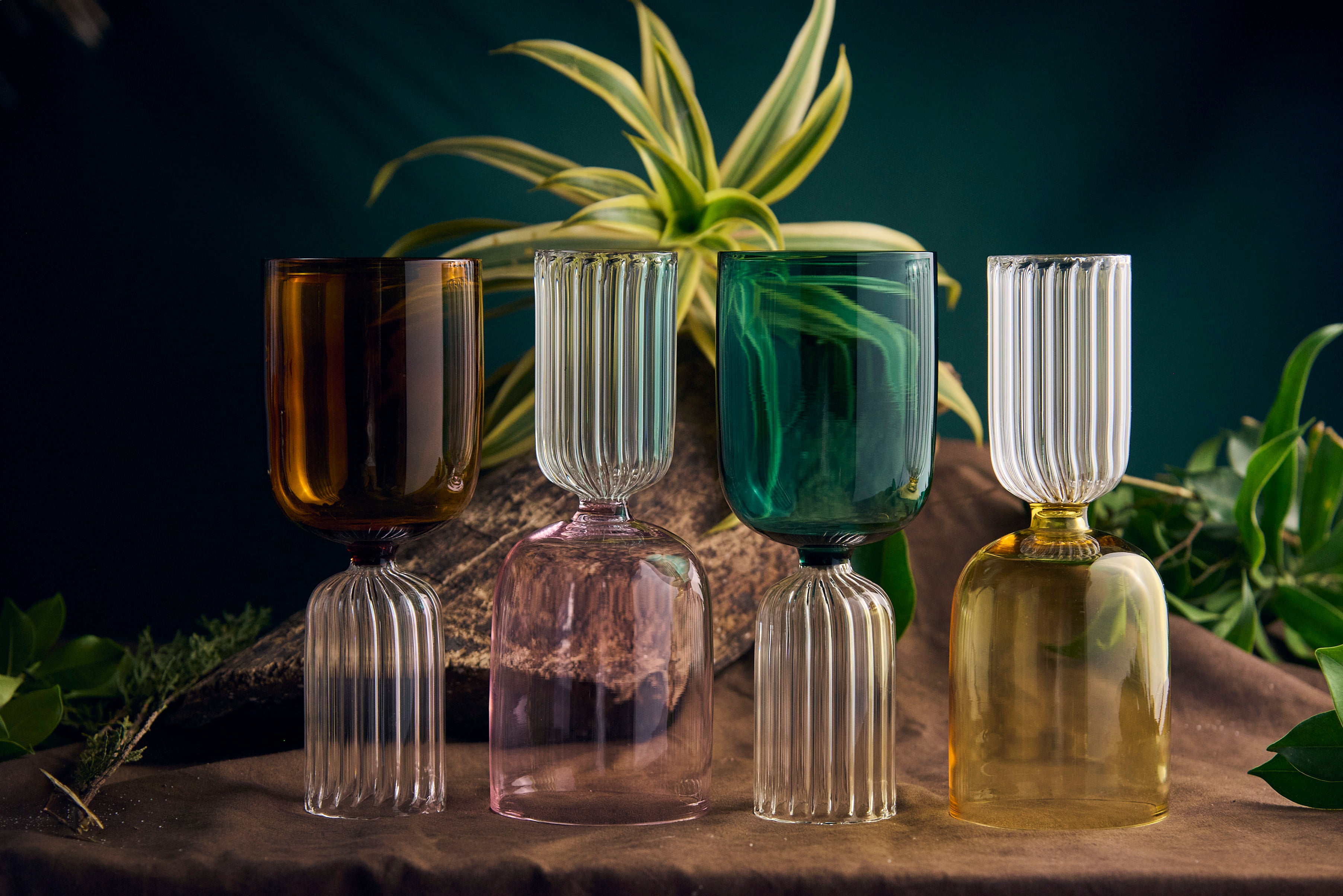 Coloured designer glassware handmade artistic drinking glass Handmade coloured designer drinking glass on modern dining table Close-up of handmade coloured glassware with artistic design Set of coloured designer glassware handmade drinking glasses Artistic coloured designer glassware modern drinking glass